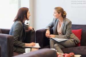 Business people talking face to face in lobby