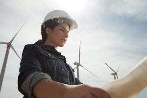 Female engineer at wind farm with plans