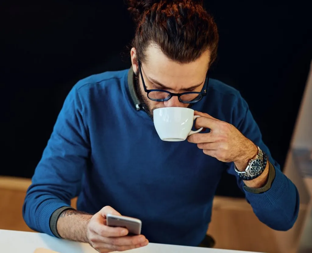 Man with glasses drinking coffee