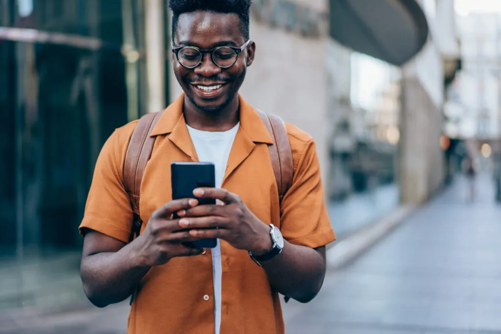 African american man using phone in street