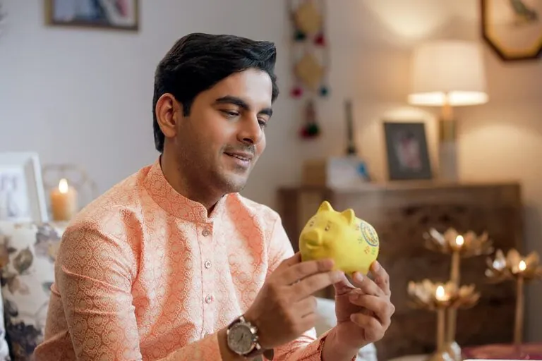 Indian man holding a piggy bank